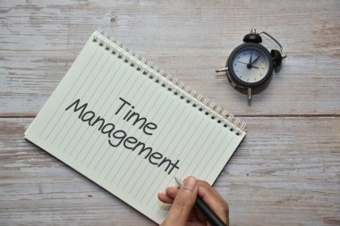 Not defteri ve analog alarm saatinde Time ManageMENT ile bir kalem tutuyorum. İş konsepti.