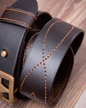 Tahta minimalist arka planda bükülmüş kahverengi kemer.