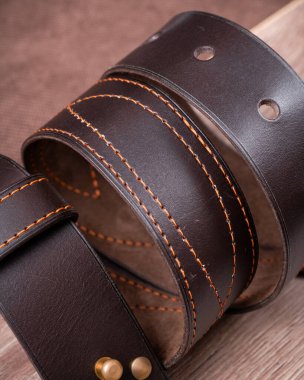 Tahta minimalist arka planda bükülmüş kahverengi kemer.