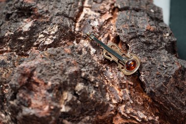 Huş ağacının arka planına karşı bronz keman ve kehribar şeklinde dekorasyon