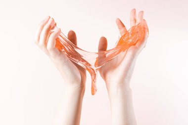 Honey drips over two womens hands close-up on a light beige background