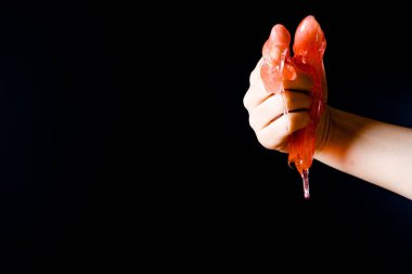 Tüy dökümü için sıvı mum damlatan işaret parmağı, siyah arkaplandaki yönü gösterir.