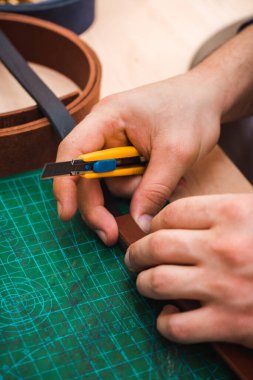 Deri kurusıkı kurusıkı ve kırtasiye bıçağı efendinin elinde.