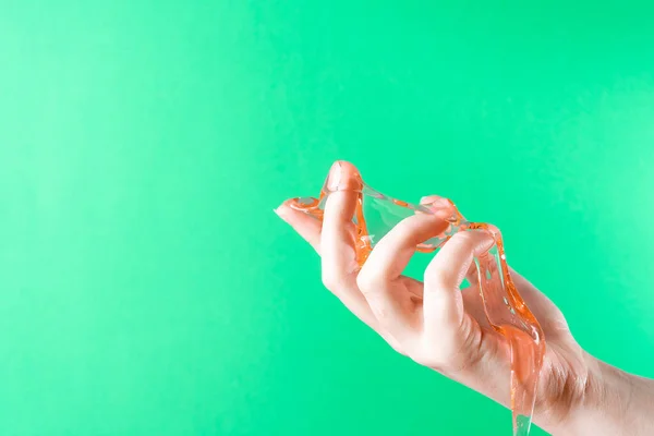 Slime spreads on the fingers against the background of green ChromaKey