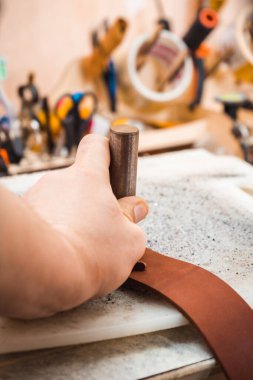 Ustanın ellerindeki deriyi yüzmek için bir keski.