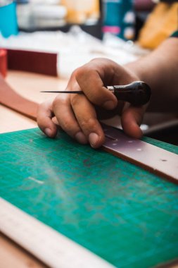 Deri ustalarının elleri kemerin deri şablonunu ölçer.