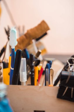 Ahşap bir stantta deri ürünler üretmek için araçlar