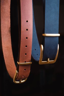 Siyah arka planda mavi ve siyah deri kayışlar.