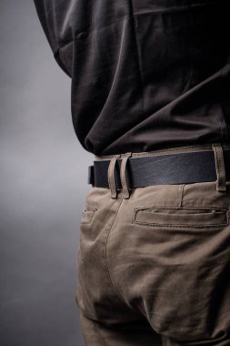 Genç adamın belinde siyah deri kemer.