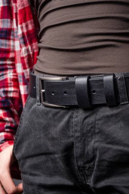 Kadınların belinde gümüş tokalı siyah deri kemer.