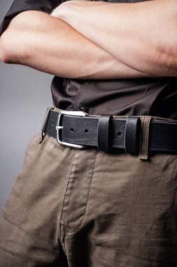 Genç adamın belinde siyah deri kemer.