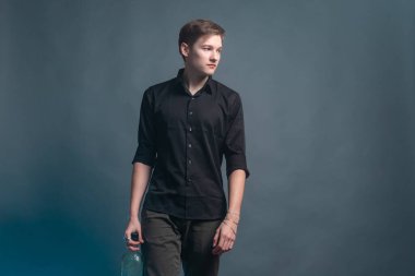 Adam gri arka planda mavi dumanlı ve bir şişe alkollü yürüyor