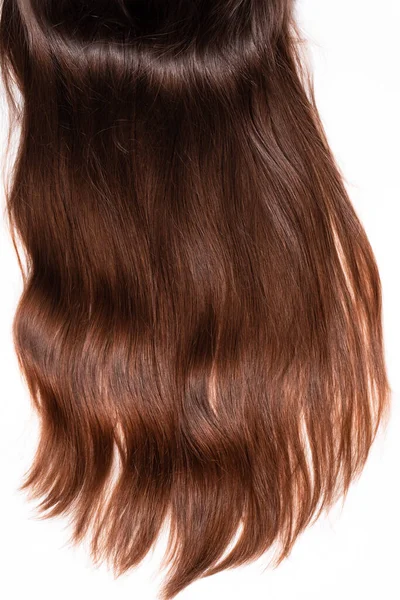 Strand of dark brown hair on a white background