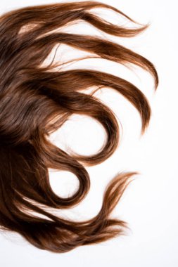 Koyu kahverengi saçlar beyaz arka planda yatar.