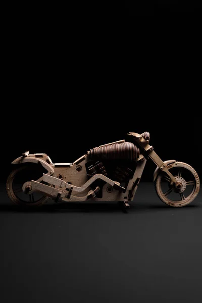Wooden toy motorcycle on a black background a close up — Stock Photo, Image