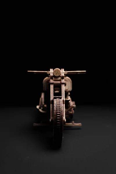 Designer av trä i form av en motorcykel på en svart bakgrund — Stockfoto