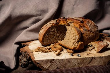Ekmek ve kurutma koyu bir arka planda, tahta bir tahtanın üzerinde yatıyor.