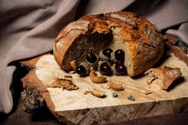 Ekmek ve kurutma koyu bir arka planda, tahta bir tahtanın üzerinde yatıyor.