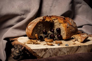 Ekmek ve kurutma koyu bir arka planda, tahta bir tahtanın üzerinde yatıyor.