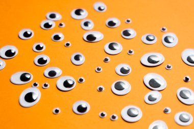 Turuncu arka planda bir grup oyuncak göz.