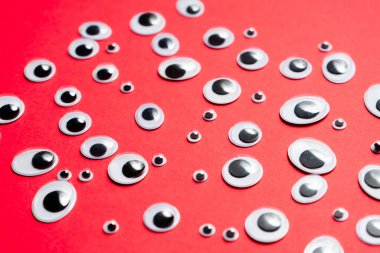 Kırmızı arka planda bir grup oyuncak göz.