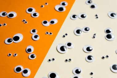 Çok renkli bir arkaplanda bir sürü oyuncak göz emojisi var.