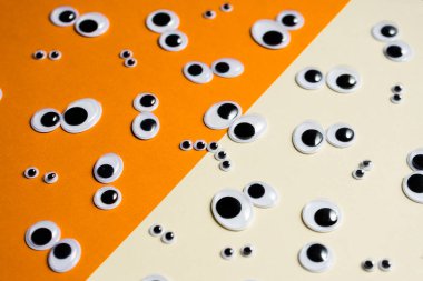 Çok renkli bir arkaplanda bir sürü oyuncak göz emojisi var.