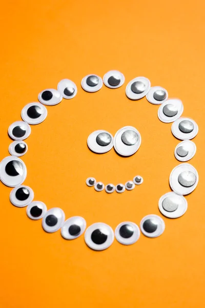 Känslomässig smiley ansikte från leksak ögon på orange bakgrund — Stockfoto