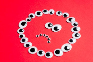 Kırmızı arka plandaki oyuncak gözlerden duygusal gülen yüz