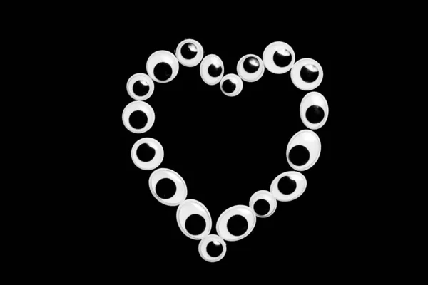 Olhos de brinquedo na forma de um coração em um fundo sulfúrico — Fotografia de Stock