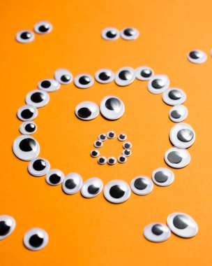 Turuncu arka planda oyuncak gözlerden duygusal gülen yüz