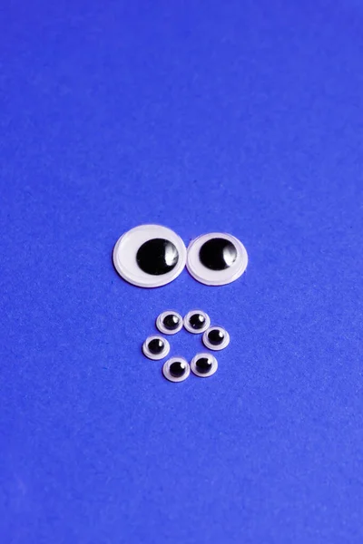 Sorrisi da occhi giocattolo su uno sfondo viola — Foto Stock
