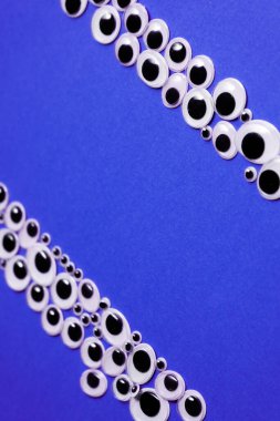 Monokrom mor arkaplandaki oyuncak gözlerden gelen metin çerçeveleri