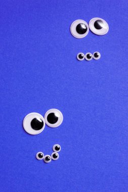 Mor arka planda oyuncak gözlerden gelen gülümsemeler