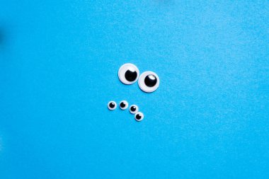 Mavi arka planda oyuncak gözlerden gelen gülümsemeler