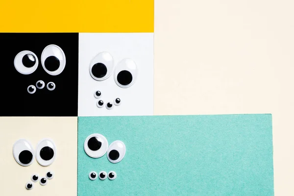 Smileys aus Spielzeugaugen auf hermetischem, mehrfarbigem Hintergrund Stockfoto