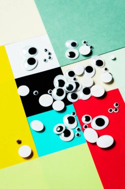 Çok renkli bir arka plana saçılmış bir grup oyuncak göz.