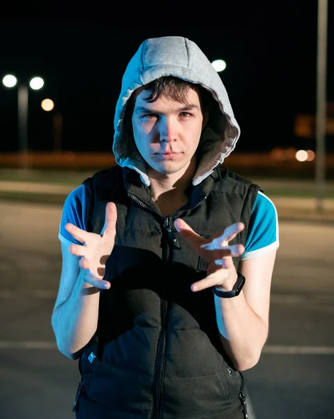 Guy at night in the parking lot against the background of lanterns — Stock Photo, Image