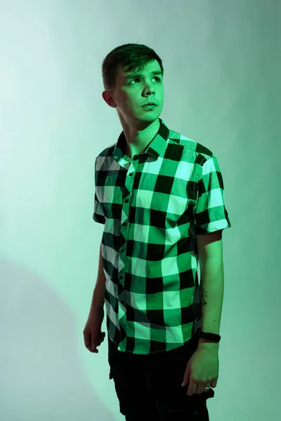 Portrait d'un jeune homme illuminé par un feu vert, sur fond blanc — Photo