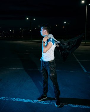 Geceleri fenerlerin arasında otoparkta genç bir adam