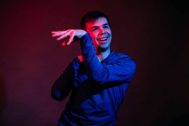 Siyah arka planda mavi ve kırmızı ışığı olan bir stüdyodaki adamın duyguları.