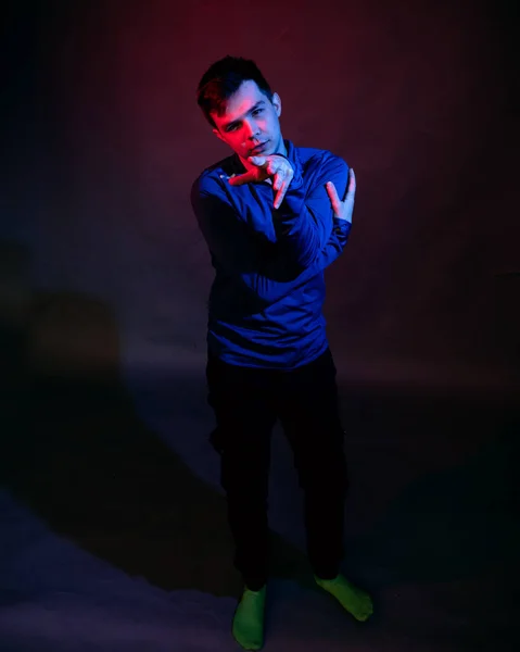 Känslor av en kille i en studio med blått och rött ljus på en svart bakgrund — Stockfoto