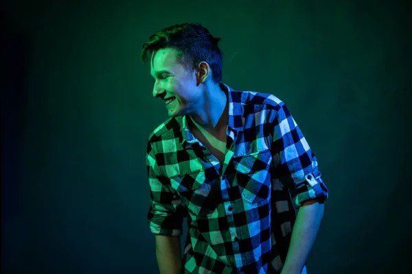 Un jeune homme danse en studio avec un feu bleu et vert — Photo