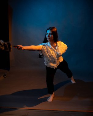 Siyah arkaplanda toz fırçası olan beyaz gömlekli bir kız.