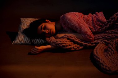 Kız yerde yatıyordu, pembe bir ekoseyle kaplıydı, sıcak bir ışıkla aydınlatılmıştı.