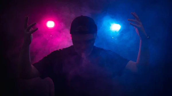 La silhouette d'un homme sur fond de fumée, consacrée par la lumière rouge et bleue — Photo