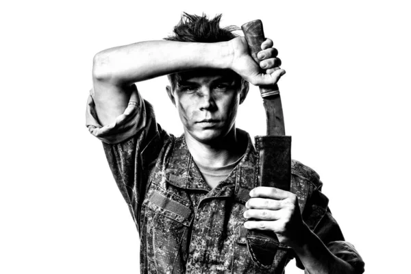 Un joven soldado en color combate saca un machete sobre un fondo blanco. Retrato en contraste blanco y negro. — Foto de Stock