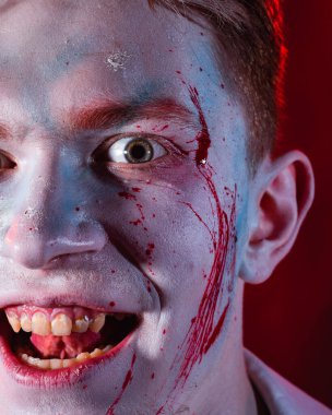 Yüzünde koyu bir arka planda ağlayan şakacı bir psikopatın yakın plan portresi.