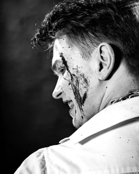 Retrato en blanco y negro de un maníaco con sangre en la cara sobre un fondo oscuro — Foto de Stock