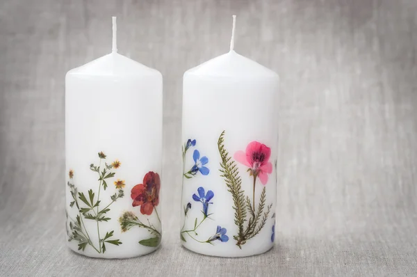 Свеча с цветами гербария на льняной ткани — стоковое фото